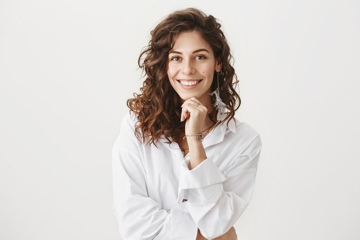 Uma mulher, jovem sorrindo como cultivar o amor-próprio.