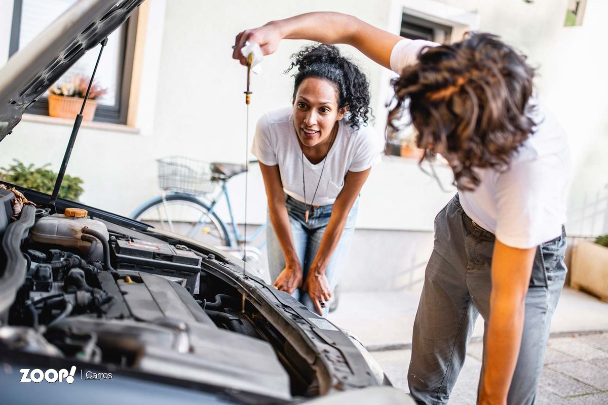 Duas pessoas verificando o nível de ólheo do carro ilustram nosso artigo sobre: Manutenção preventiva: deixe seu carro sempre em dia.