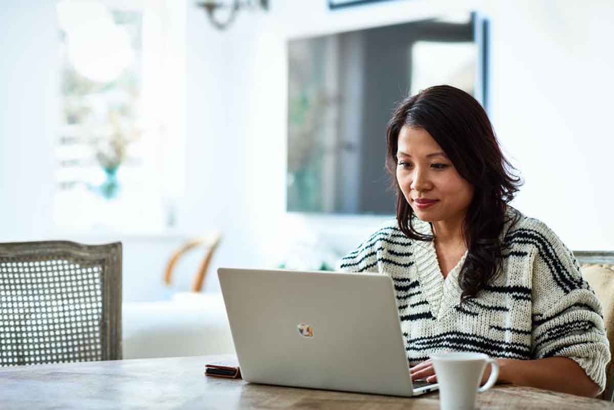 Mulher morena fazendo delaração de imposto de renda usando notebook