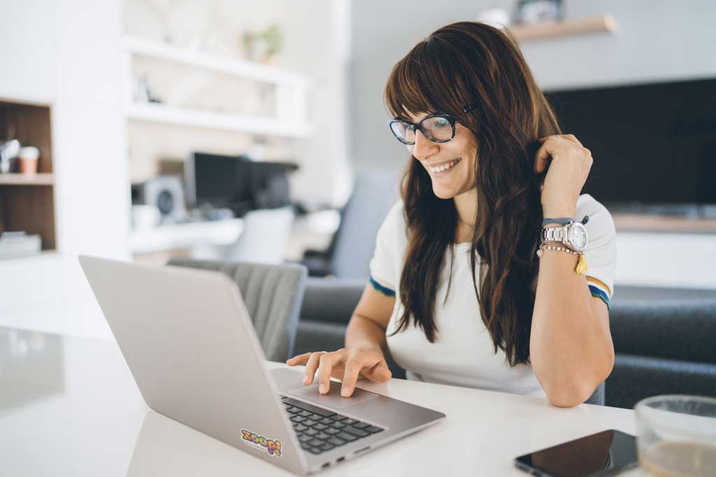 Mulher morena de óculos usando notebook ilustra nosso artigo sobre: Ferramentas gratuitas que podem ajudar na promoção de cursos online em redes sociais.