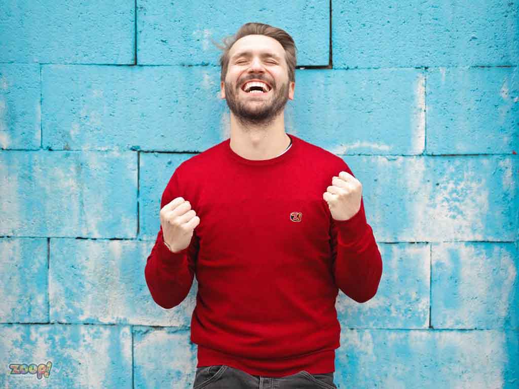 Homem usando camisa vermelha comemorando por ter mais sorte na vida