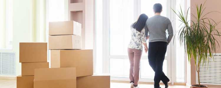 Casal jovem, abarçados, em seu novo apartamento.