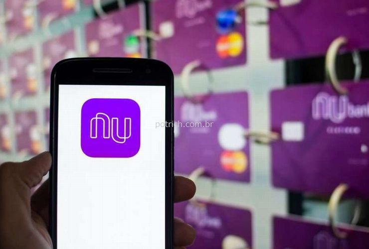 Uma pessoa mostra o celular com a marca do Nubank para ilustrar nosso artigo sobre: Home office da Nubank vai até o final de 2020.  