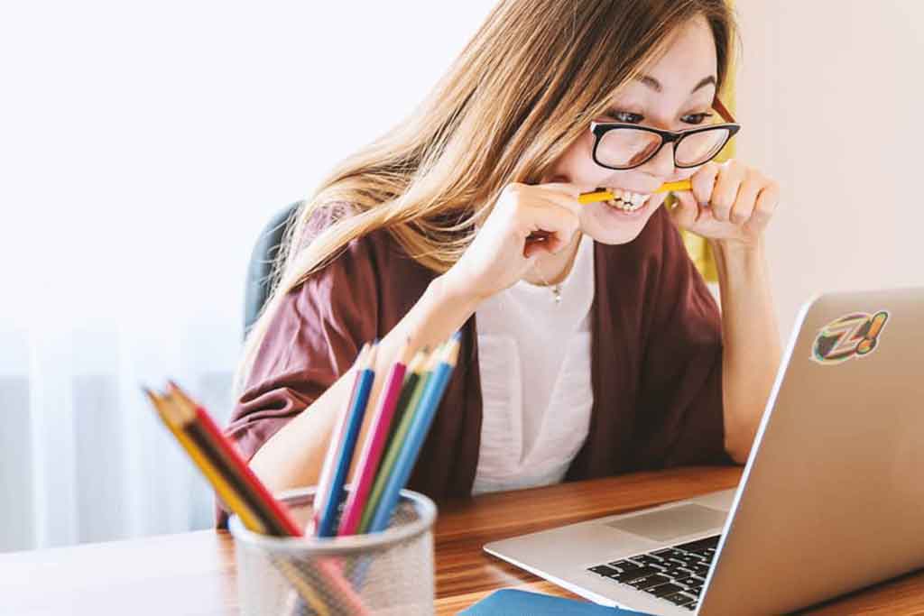 Um mulher jovem aprendendo inglês sozinha estudando pela internet;